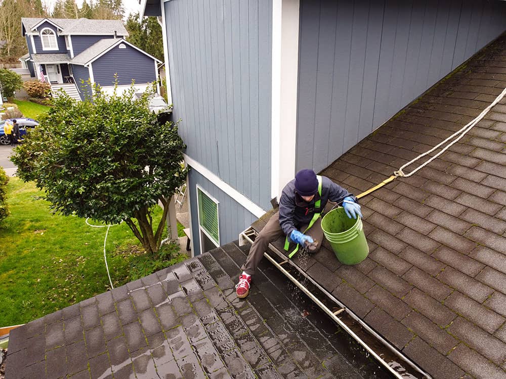 gutter cleaning professional cleaning gutter on blue home