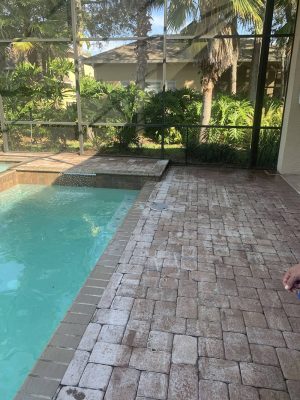 paver walkway and deck next to pool before cleaning