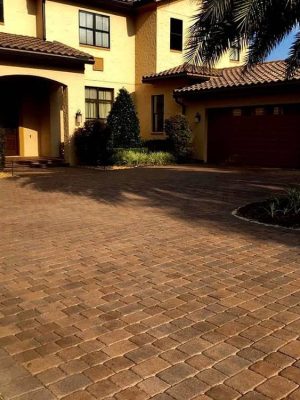 pavers in front of yellow home before cleaning